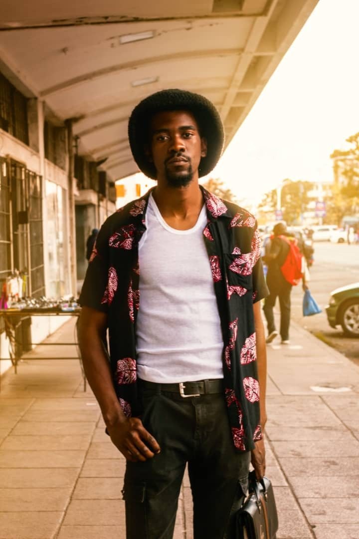 Den Creus in the street, patterned shirt, bag in hand